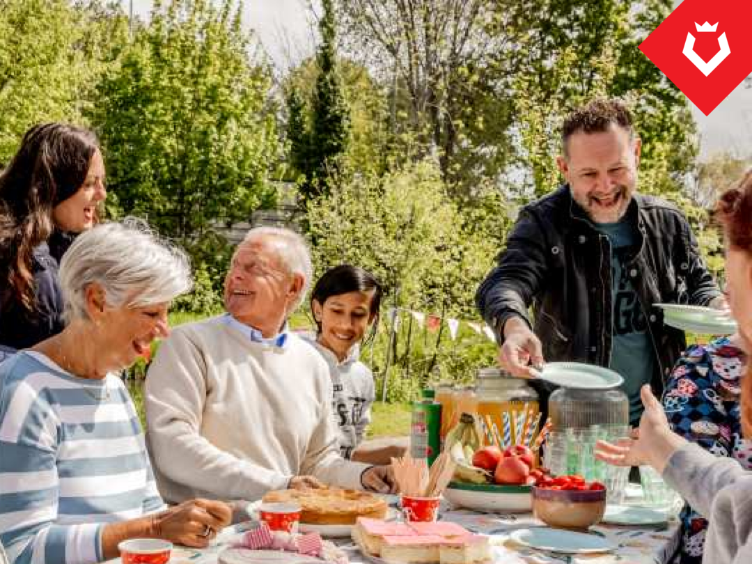 Foto van buren die gezellig in het zonnetje samen eten en drinken