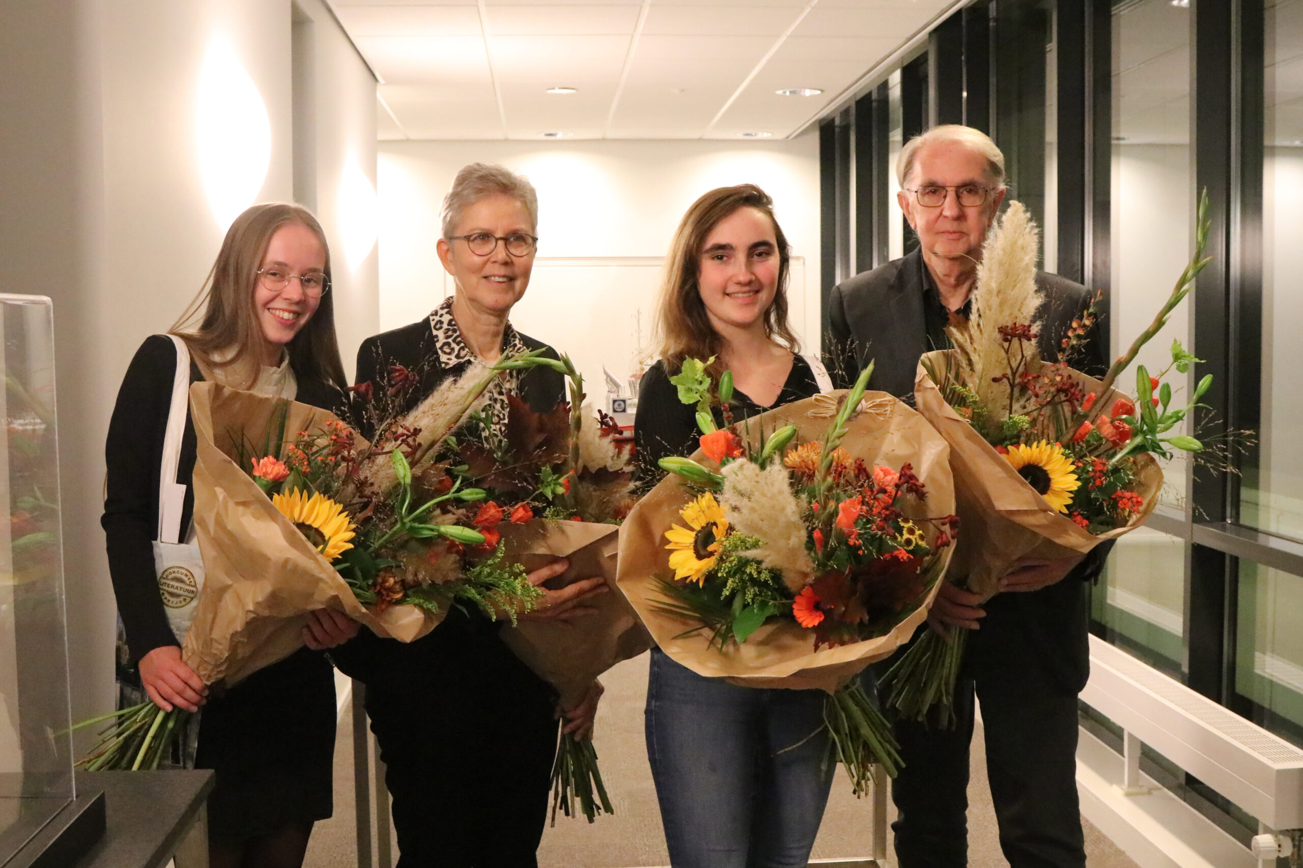 Foto van vier prijswinnaars van de Gorcumse Literatuur Prijs met bloemen