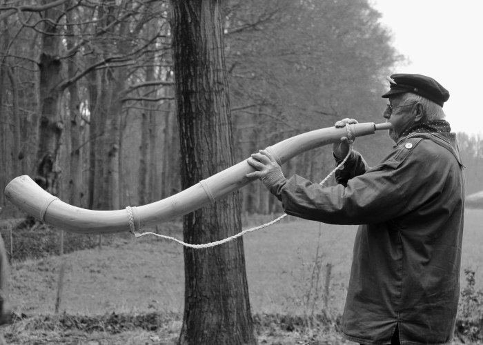 Foto van man die blaast op een hoorn