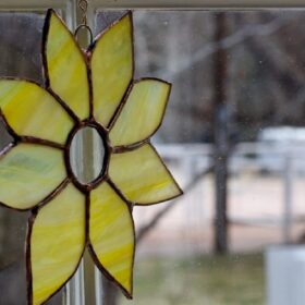 Foto van een gele bloem gemaakt van glas met de techniek tiffany.