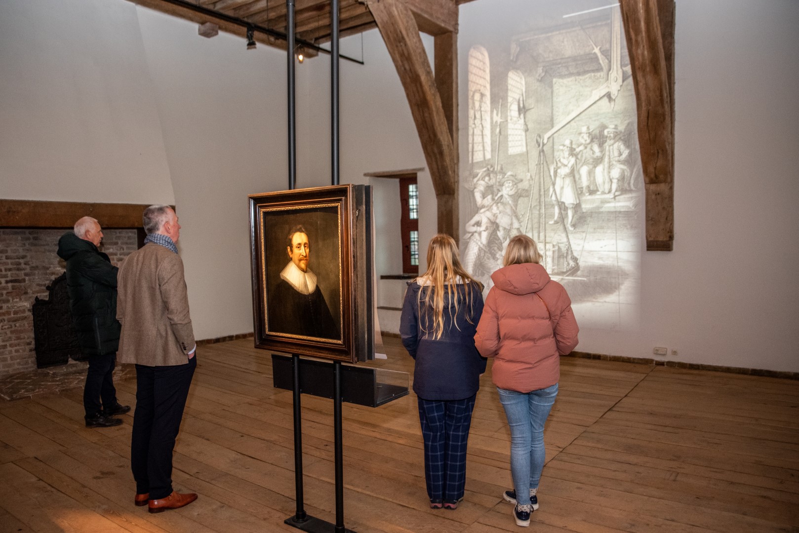 Foto van drie mensen die kijken naar kunst Hugo de Groot