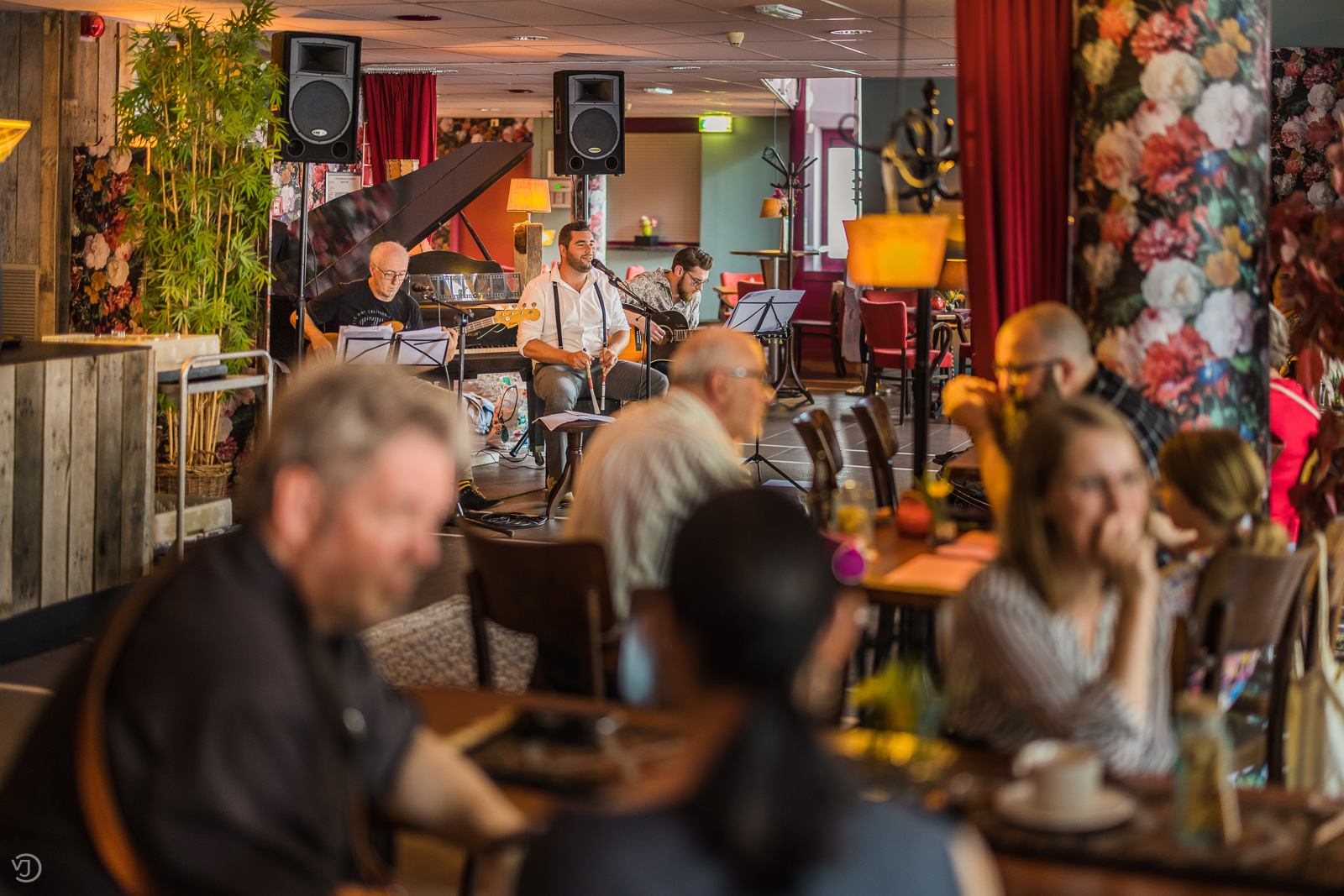 Foto van een aantal mensen zittend in het café van De Nieuwe Doelen.