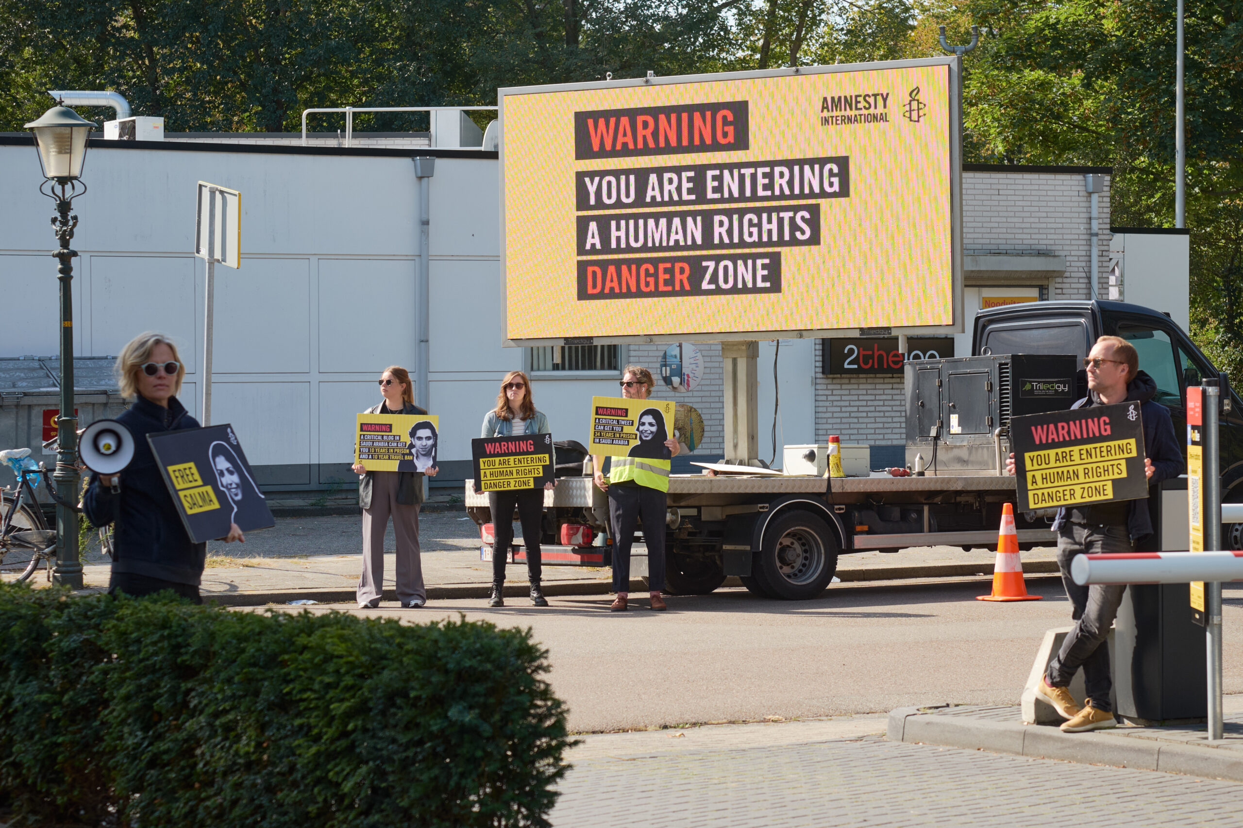 Activisten die protesteren bij een bord met leus
