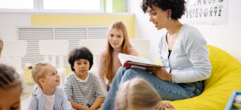 Foto van volwassene die voorleest aan een groepje kinderen